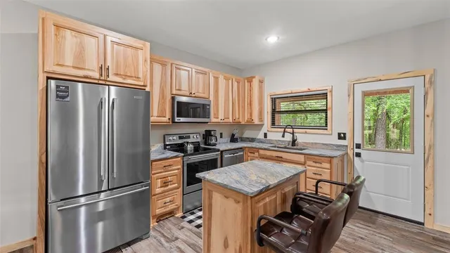 a kitchen with granite countertop stainless steel appliances a refrigerator stove and microwave