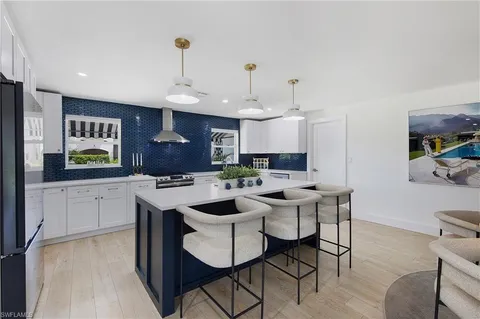 a kitchen with a sink and chairs