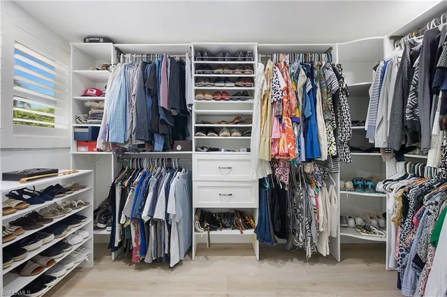 a view of walk in closet with clothes and shoes