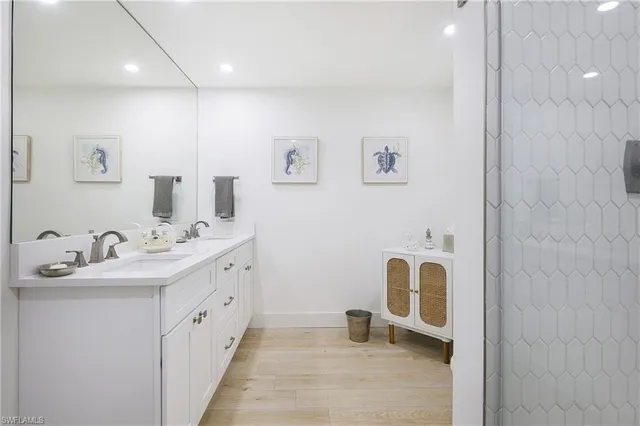 a bathroom with a double vanity sink mirror and bathtub