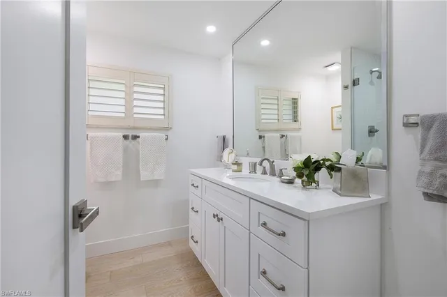 a bathroom with a sink a mirror a vanity and a bathtub