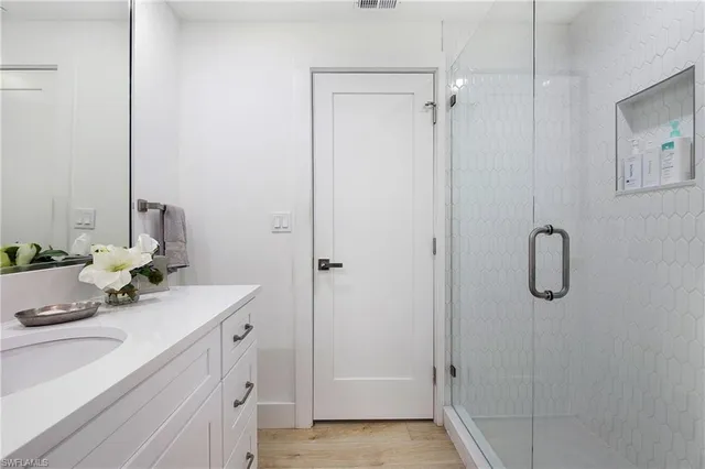 a bathroom with a sink vanity and shower