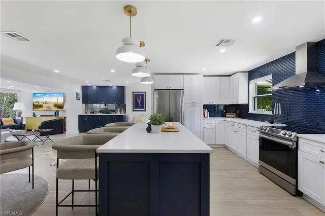 a kitchen with a dining table cabinets stainless steel appliances and kitchen counter space