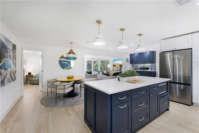a large kitchen with a table chairs and refrigerator