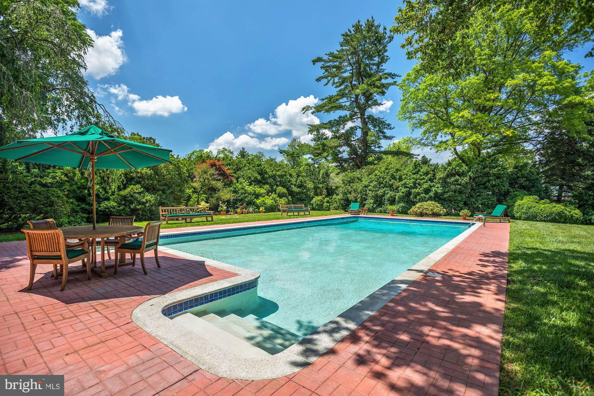 13032 Highland Road Highland, MD 20777 - Photo 68 of 114 a view of a swimming pool with a table and chairs under an umbrella