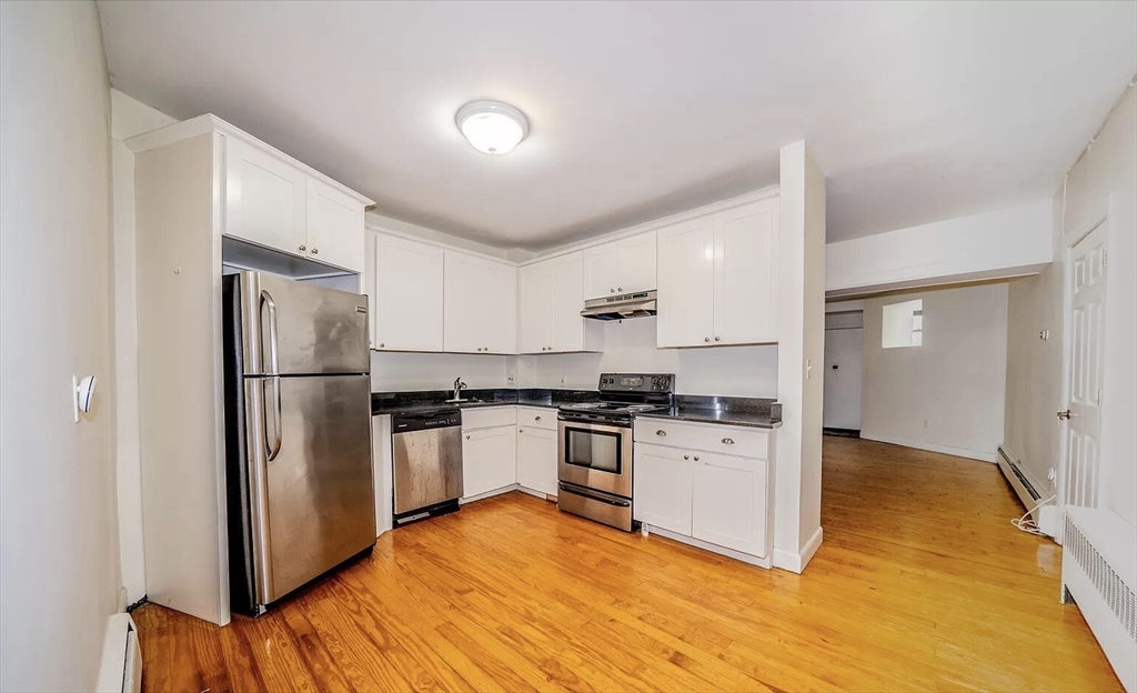 1728 Beacon Street, Unit B Brookline, MA 02445 - Photo 2 of 10 a kitchen with stainless steel appliances granite countertop a refrigerator sink and stove