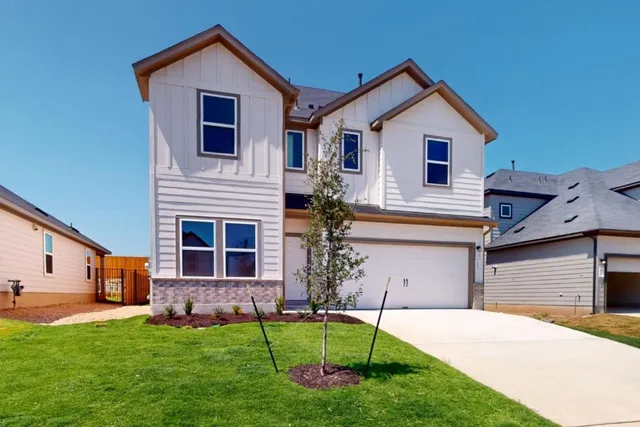 a front view of a house with a garden and plants