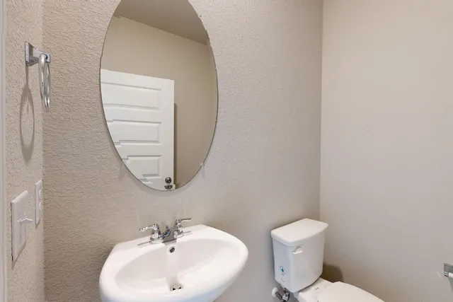 a bathroom with a sink a mirror and a toilet