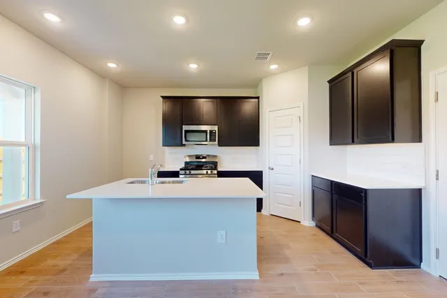 a large kitchen with kitchen island a sink stainless steel appliances and cabinets