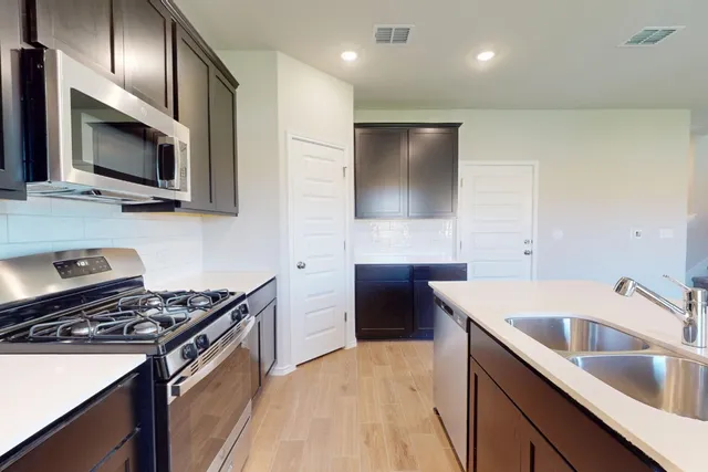 a kitchen that has a sink and a stove top oven