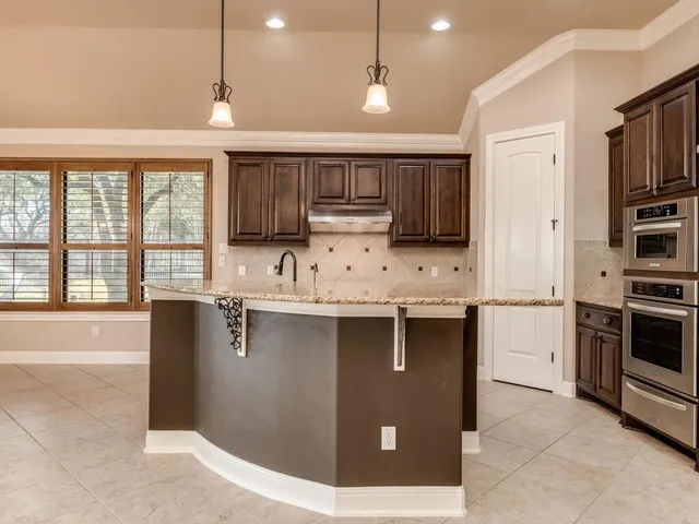 a kitchen with stainless steel appliances granite countertop a stove a sink a refrigerator and a microwave