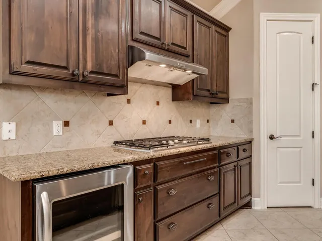 a stove top oven sitting inside of a kitchen