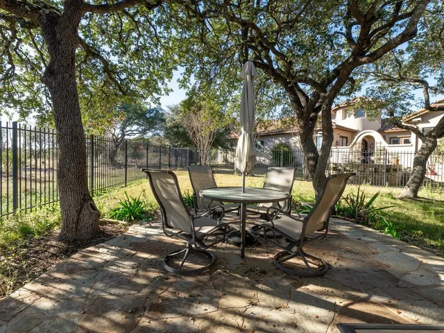 a view of a park with iron fence and a bench