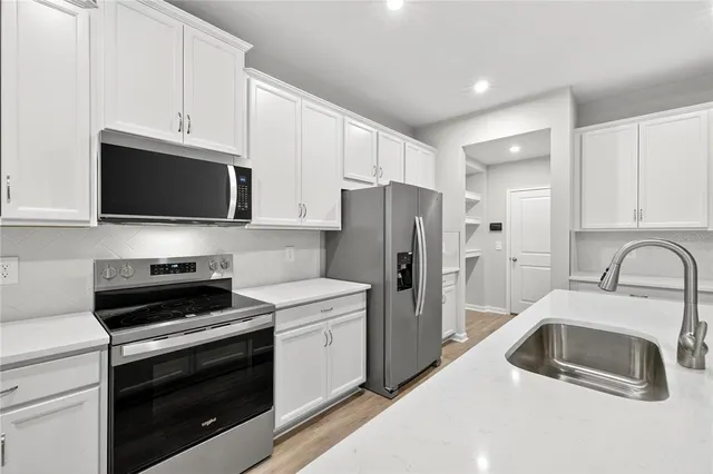 a kitchen with kitchen island a sink stainless steel appliances and cabinets