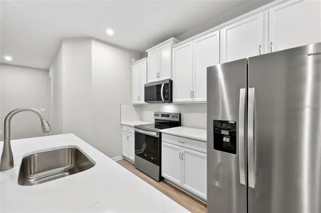 a view of kitchen with stainless steel appliances refrigerator oven microwave and stove