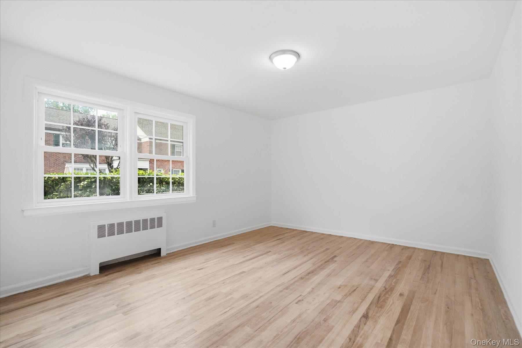 117 Robins Road, Unit 117 New Rochelle, NY 10801 - Photo 18 of 28 an empty room with wooden floor and windows