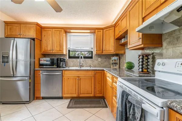 a kitchen with stainless steel appliances granite countertop a refrigerator sink and stove