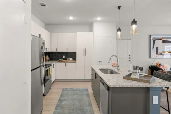 a kitchen with kitchen island granite countertop a sink and refrigerator