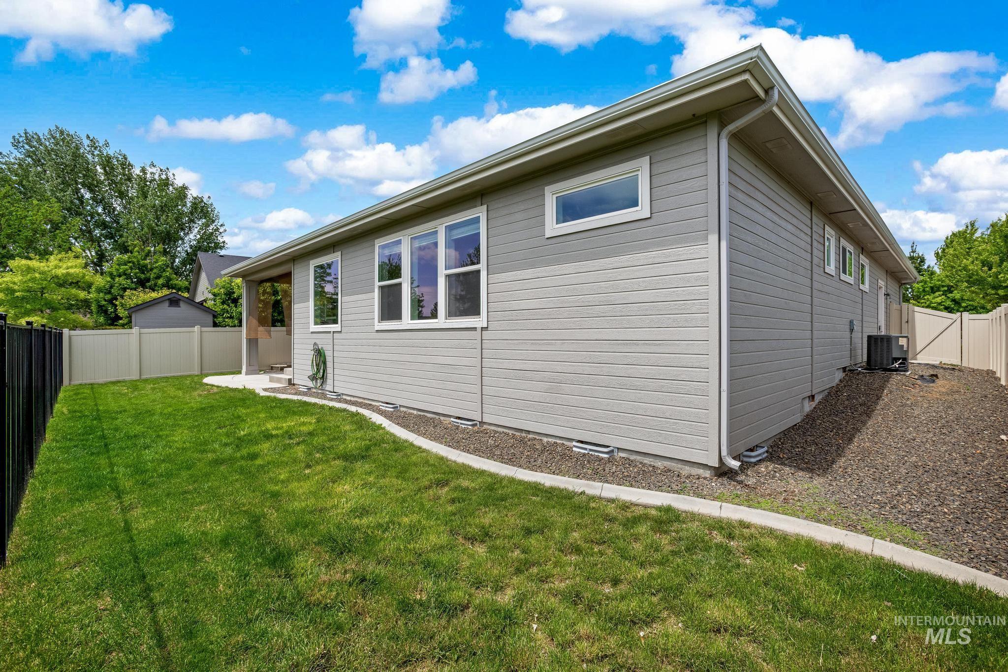 2681 East Rhyolite Court Nampa, ID 83686 - Photo 40 of 48 Exterior featuring horizontal siding, multiple windows, an air conditioning unit, a concrete patio area, and a gravel border