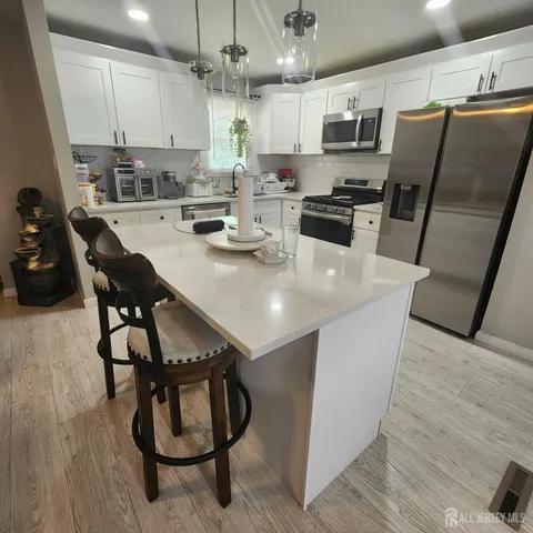 a kitchen with stainless steel appliances a table chairs and a refrigerator