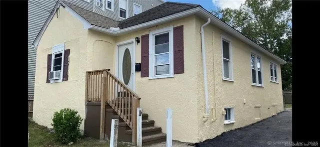 a view of a house with stairs and wooden fence