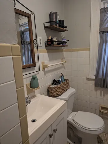 a bathroom with a toilet a sink and a mirror