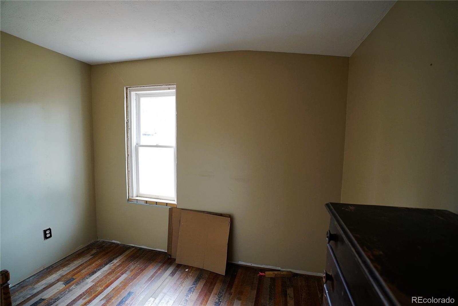 186 Anderson Road Bailey, CO 80421 - Photo 8 of 15 a view of an empty room with wooden floor and a window