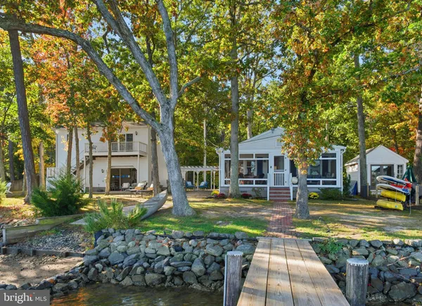 a front view of a house with a yard and trees
