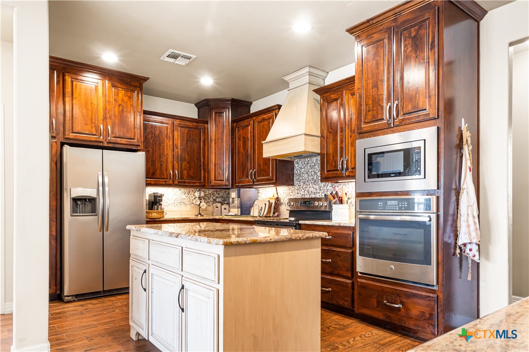 790 Spanish Grant Road Goliad, TX 77963 - Photo 13 of 41 a kitchen with stainless steel appliances granite countertop a refrigerator a stove and a sink with large window