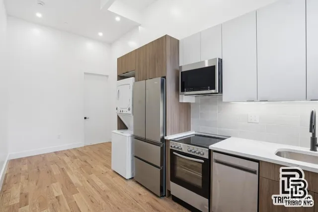 a kitchen with stainless steel appliances a refrigerator stove and microwave