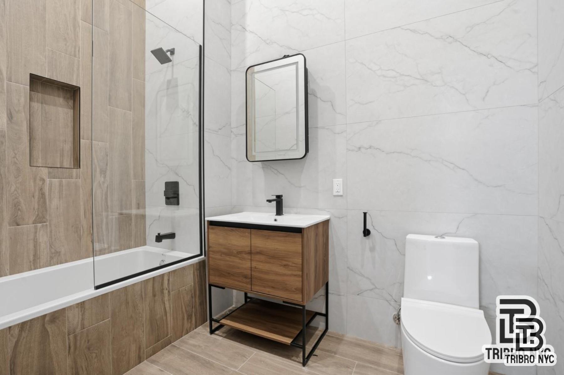 1112 Fulton Street, Unit 1 Brooklyn, NY 11238 - Photo 7 of 9 a bathroom with a toilet a sink and mirror