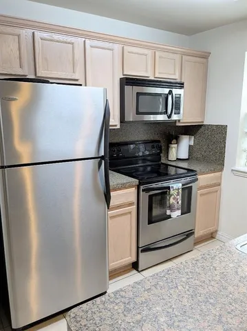 a white refrigerator freezer and a stove sitting inside of a kitchen