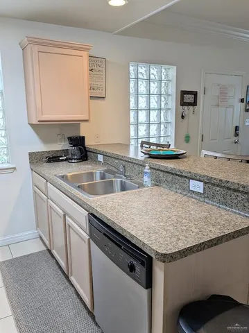 a kitchen with granite countertop a sink stove and cabinets