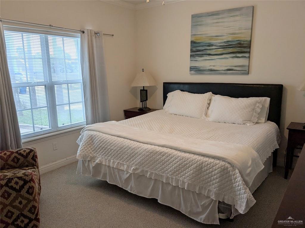 109 East Retama Street, Unit 1 South Padre Island, TX 78597 - Photo 8 of 16 a bedroom with a bed and glass window