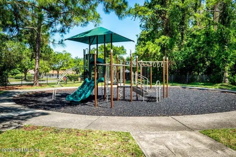 a view of a park with slide and a bench