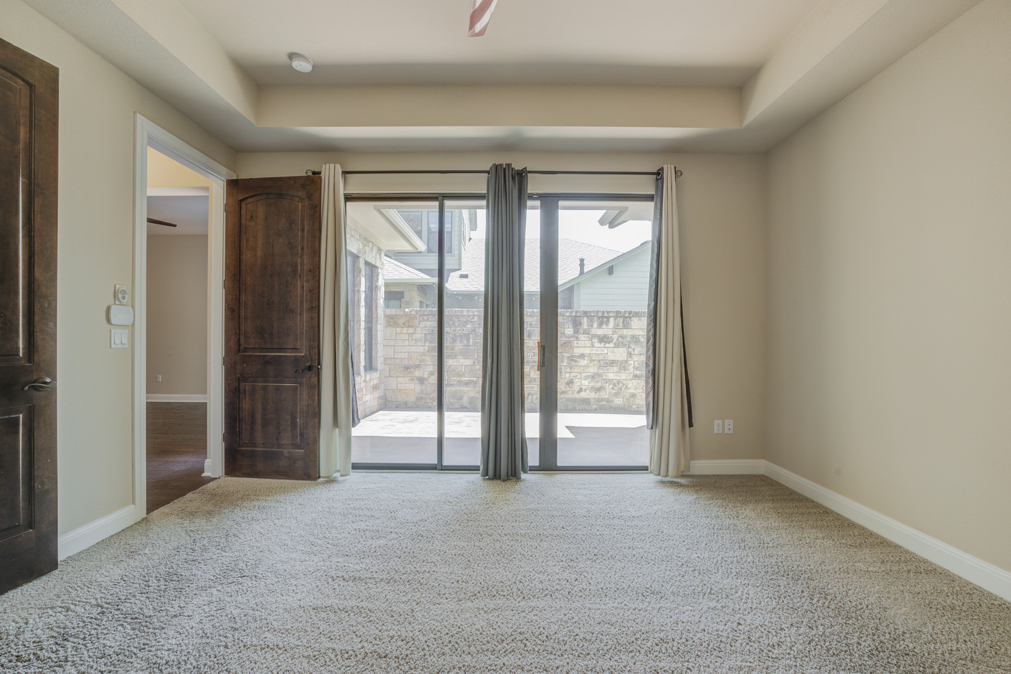 4524 Berkman Drive Austin, TX 78723 - Photo 21 of 38 Carpeted room with a tray ceiling and a sliding glass door opening to a private patio