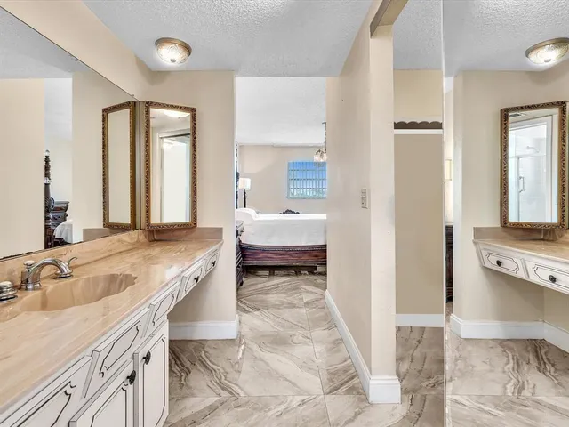 a bathroom with a granite countertop sink mirror and toilet