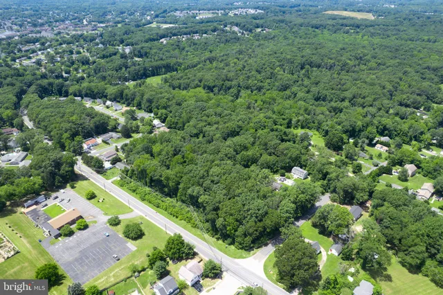 an aerial view of residential house with outdoor space and trees all around