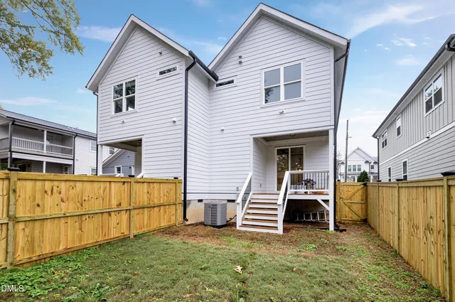 a view of a house with backyard and wooden fence