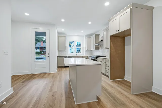 a kitchen with stainless steel appliances granite countertop a refrigerator and a stove top oven
