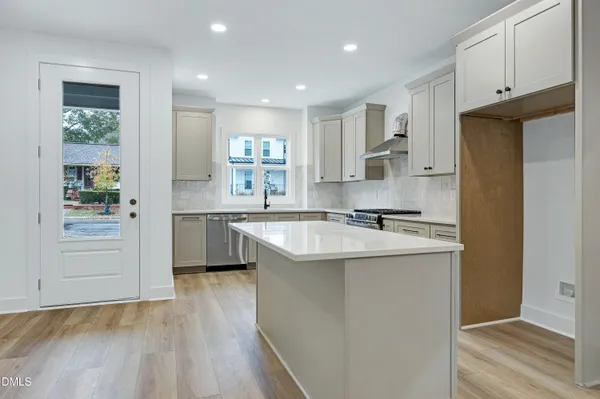 a kitchen with a sink white cabinets and stainless steel appliances