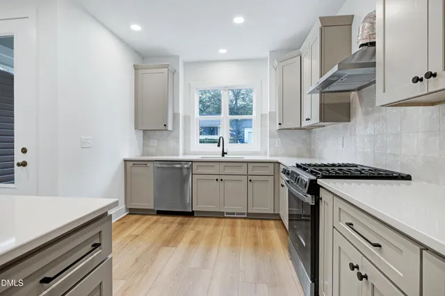 a kitchen with a sink stove top oven and cabinets