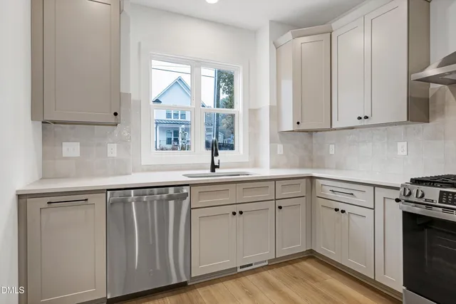 a kitchen with white cabinets and sink