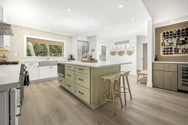 a kitchen with a table chairs refrigerator and cabinets
