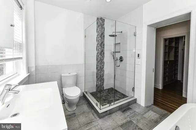 a white bath tub sitting in a bathroom next to a window