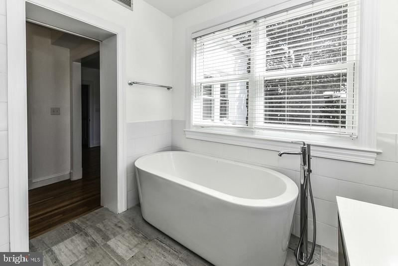 3222 Klingle Road Northwest Washington, DC 20008 - Photo 20 of 46 a white bath tub sitting in a bathroom next to a window