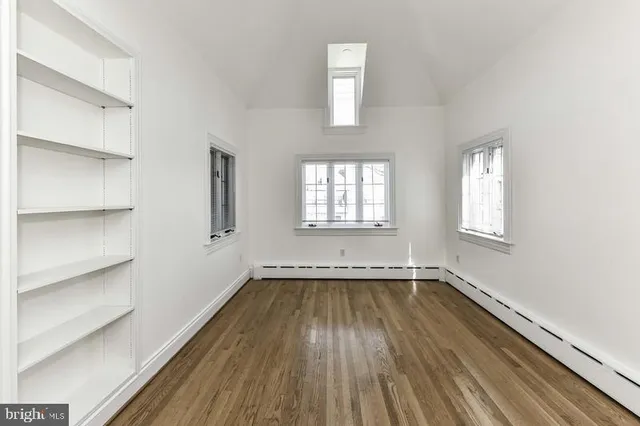a view of an empty room with wooden floor