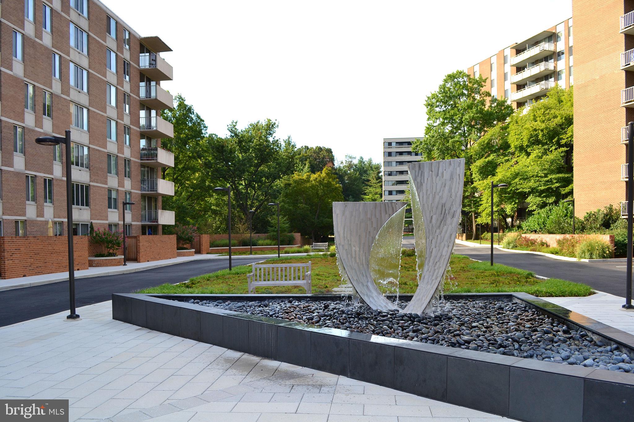 2939 Van Ness Street Northwest, Unit 630 Washington, DC 20008 - Photo 25 of 25 a view of a fountain with a bench in front of a house