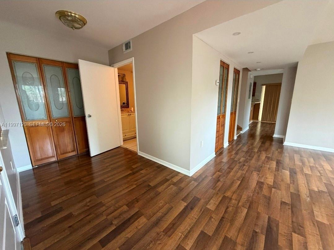 2385 West 69th Street, Unit 2385B Hialeah, FL 33016 - Photo 3 of 7 a view of an empty room with wooden floor and a window