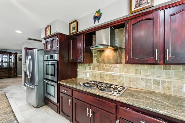 a kitchen with granite countertop cabinets stainless steel appliances a sink and dishwasher